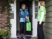 Mary Beth Nelson, left, hands her bag of food donations to Kathy Hampton on Dec. 8 in Clark County. Hampton volunteers every other month for the Clark Neighbors Food Project, which provides a steady supply of food to local pantries.