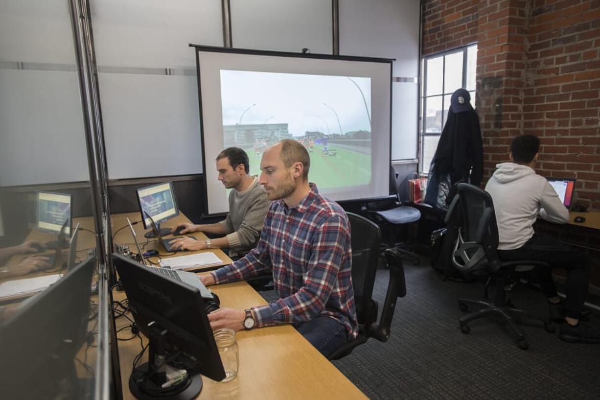 DeepCanopy President and CEO Nate Fuller, from left, Chief Operations Officer Jonathan Parnell and computer vision engineer Julian Weisbord work on the company’s computer vision software in their downtown Vancouver office.