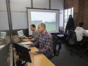 DeepCanopy President and CEO Nate Fuller, from left, Chief Operations Officer Jonathan Parnell and computer vision engineer Julian Weisbord work on the company’s computer vision software in their downtown Vancouver office.