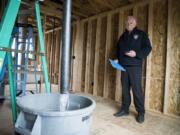 Fire Marshal Ron Schumacher does a bucket test to make sure the fire sprinkler system has adequate water output in a new home in Camas. Two sprinklers must provide at least 26 gallons of water in one minute to pass the test.