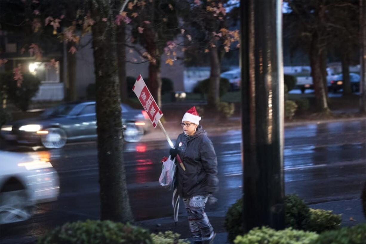 Kelly Olson, a paraeducator at Hazel Dell Elementary School, walks during a rally in front of the Vancouver Public Schools’ offices on Tuesday night.