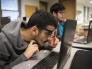 Washington State School for the Blind sophomore Dima Faraj, left, and senior Angel Patino, center, work on a lesson during the computer science principles class at Washington School for the Blind in Vancouver.