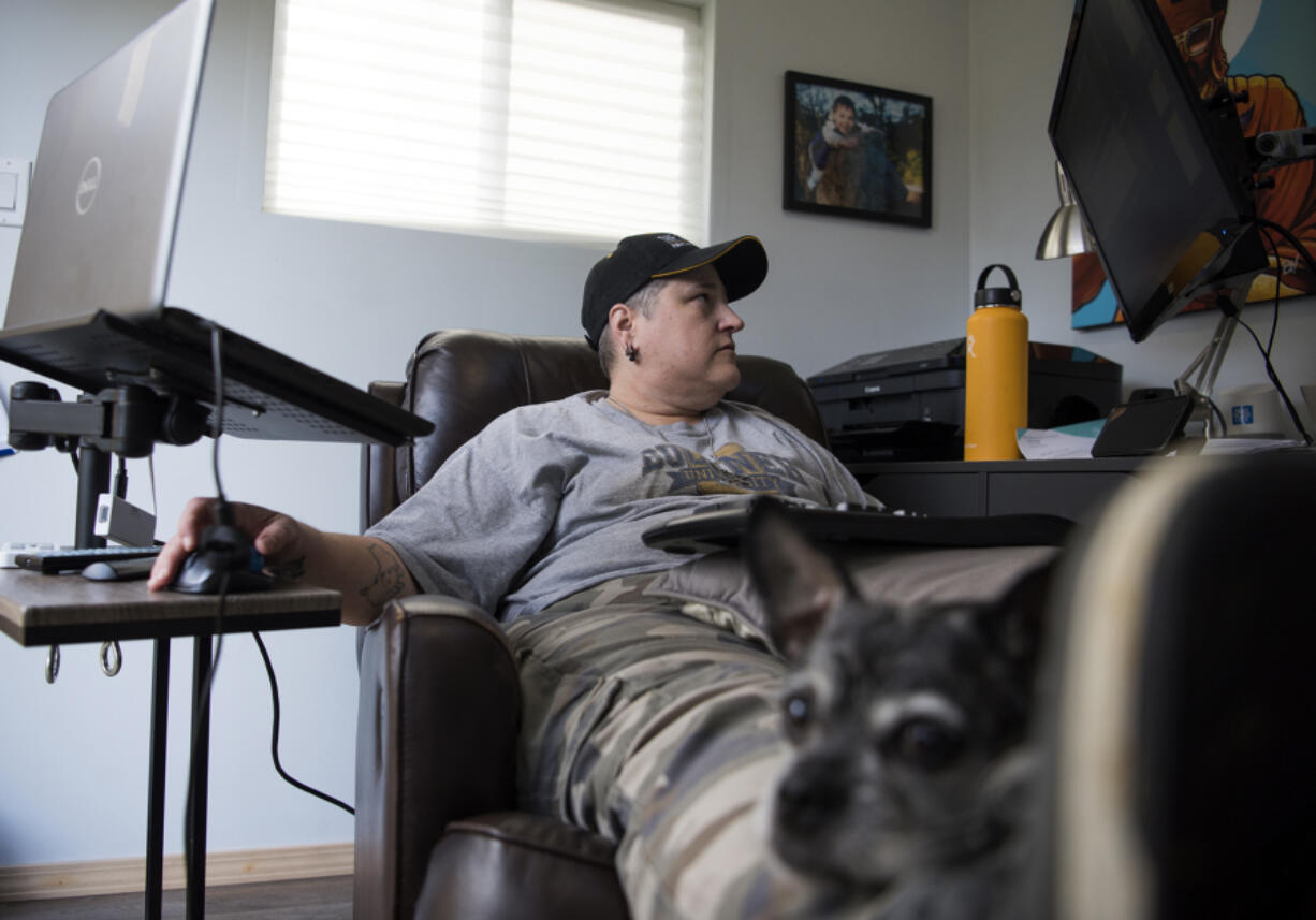 Mel Buckner’s dog, Pepper, sits on her lap as she works from her backyard office at her home in Vancouver on Thursday. After tiring of her commute to Milwaukie, Ore., Buckner, a data analyst for Providence Health Systems, began working from home about 1½ years ago.