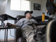 Mel Buckner’s dog, Pepper, sits on her lap as she works from her backyard office at her home in Vancouver on Thursday. After tiring of her commute to Milwaukie, Ore., Buckner, a data analyst for Providence Health Systems, began working from home about 1½ years ago.