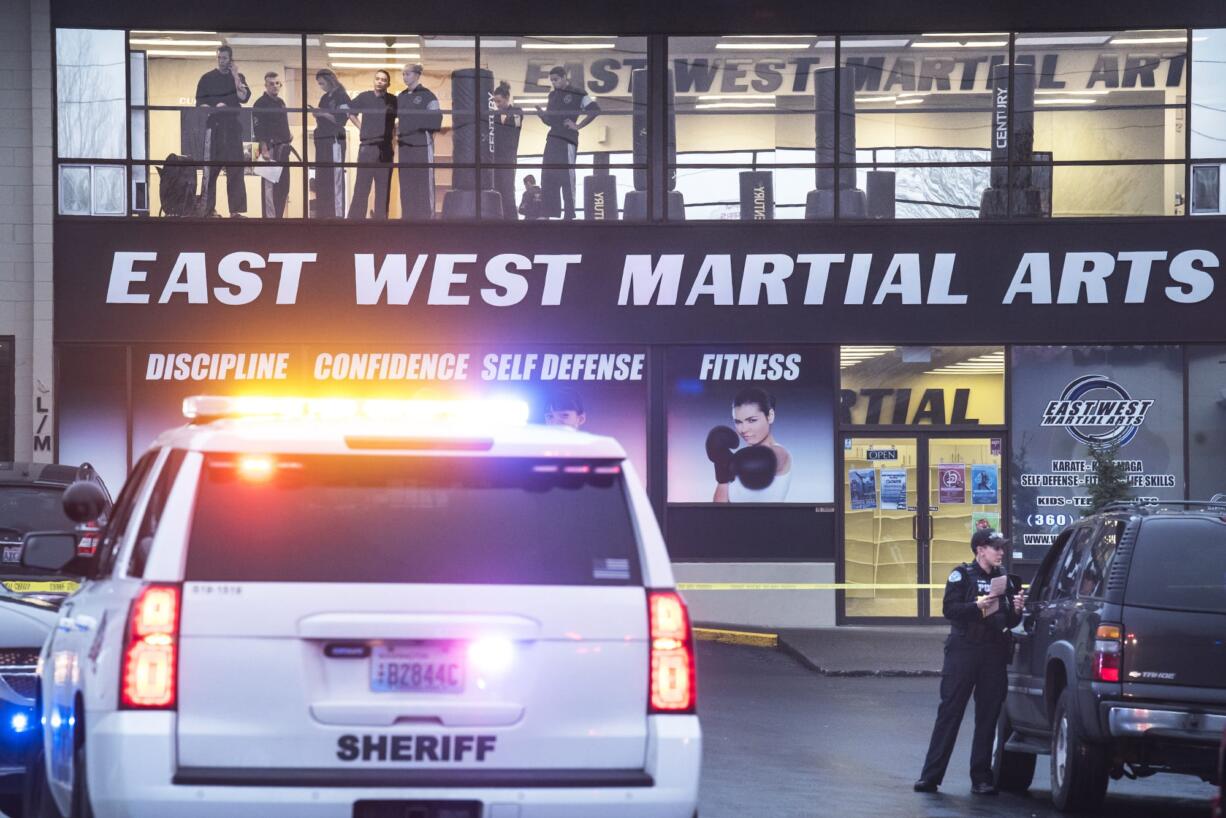 Spectators watch the investigation of a fatal shooting from the top floor of East West Martial Arts at the Pacific 63 Center in Hazel Dell on Monday afternoon, Dec. 10, 2018.