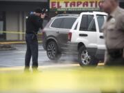 A Clark County Sheriff's investigator photographs the car of a shooting victim at Pacific 63 Center in Hazel Dell on Monday afternoon, Dec. 10, 2018.