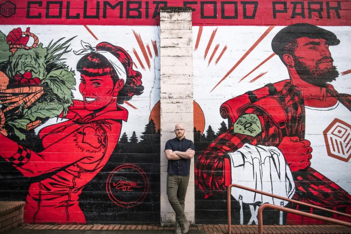 Alex Mickle, founder of the Columbia Food Park, stands in front of a new mural that adorns the eastern wall of the Columbia Food Park, painted by Portland artist Jonathan Case.