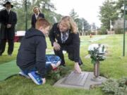 Vancouver Mayor Anne McEnerny-Ogle and Aiden Shields, place a wreath on the grave of Andrew Shields, at the National Wreaths Across America Day in Vancouver Saturday. Andrew Shields was a Battle Ground resident and combat medic killed in Afghanistan in 2008.