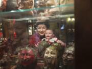 Museum guest Carmel Rosa, with son Owen Thorn, look at artifacts on display at the Devil-ish Little Things Museum in Rose Village on Sunday afternoon.