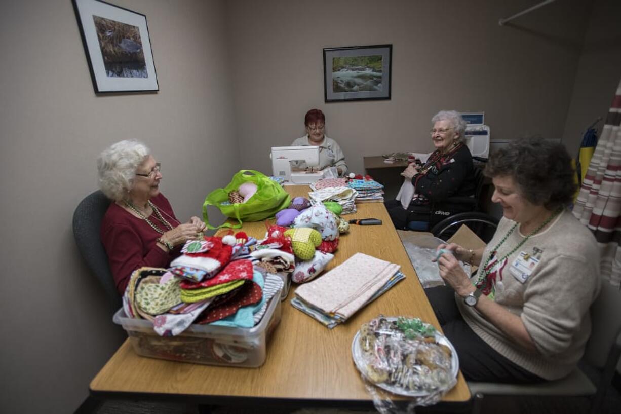 Sewing group volunteers Elsie Fernquist, clockwise from left, Floreen Clark, Betty Maas and Dana Difford work on hand-sewn gifts for babies born at PeaceHealth Southwest Medical Center in Vancouver. About 2,000 births happen at the hospital each year, and every baby gets a receiving blanket, a hat and a burping bib.