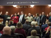 Under the gaze of families and supporters, Clark County Superior Court Judge David Gregerson, left, swears in (from left) Alishia Topper, Peter Van Nortwick, Chuck Atkins, Temple Lentz, Scott Weber and Julie Olson into their respective terms in office in Clark County government.