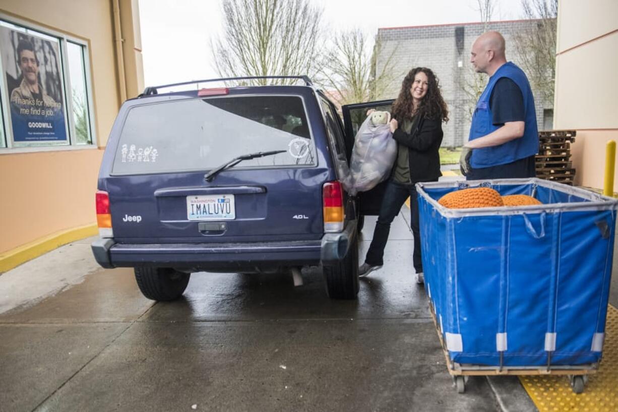 Kristi Davis of Vancouver hands a bag of stuffed animals to lead donation attendant Ken Smith. “We do most of our charitable giving through church,” Davis said.