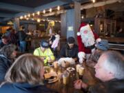 Santa gives out candy canes to people eating at WareHouse '23  on the Vancouver Waterfront on Christmas Day, December 25, 2018.