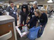 Dr. Erin Baldwin, from left, Dr. Dina Brothers, registered nurse Desiree Kauffman and registered nurse Jaimie Mogush look over toys donated for children in the emergency room at PeaceHealth Southwest Medical Center on Thursday morning.