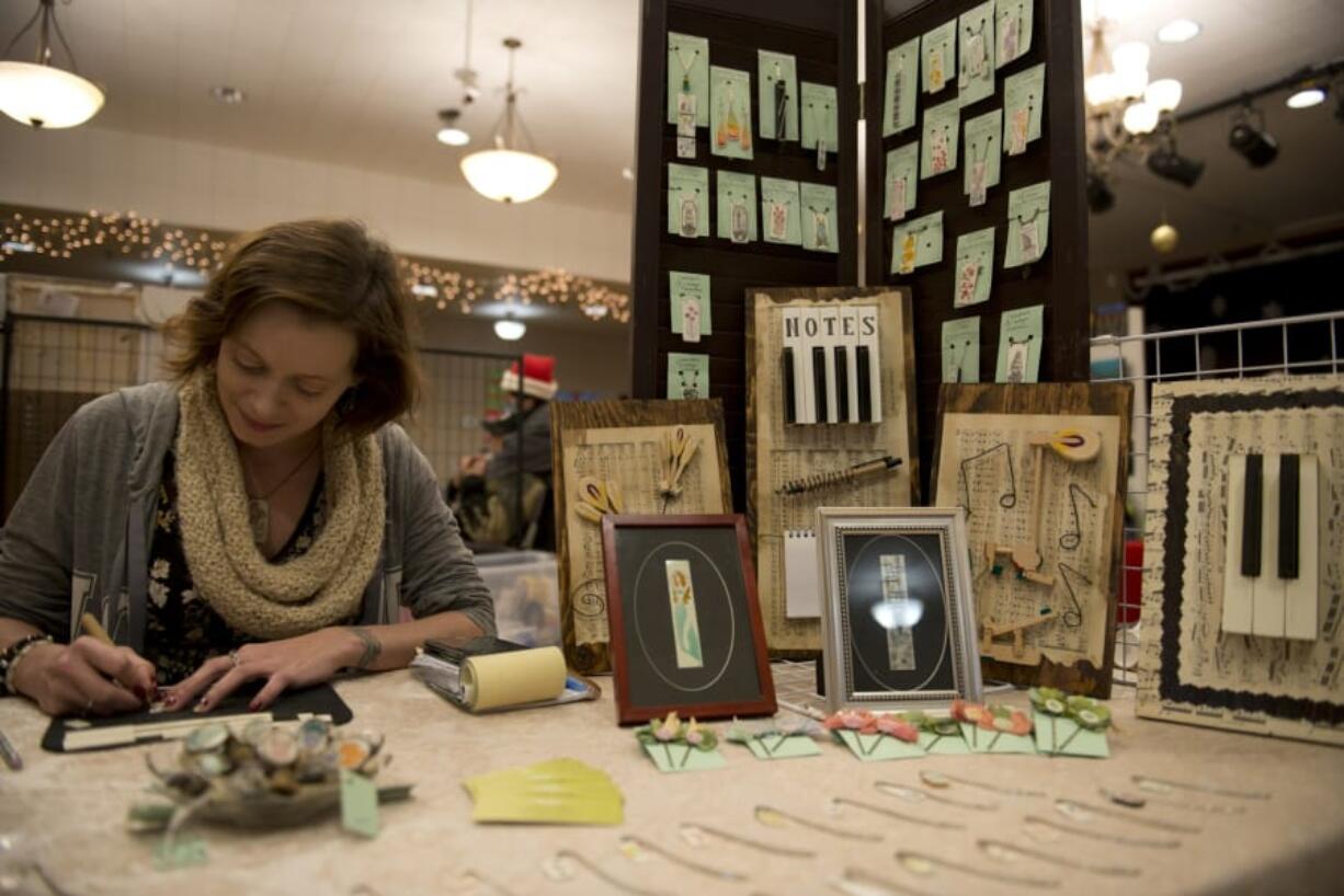 Jennifer Fuller, of Washougal, owner of Jennifer’s Vintage, works in her booth at the Holiday Vendors Market at the Vancouver Elks Lodge 823 in Vancouver. This was the first year for the market, which featured 30 booths with handmade art.