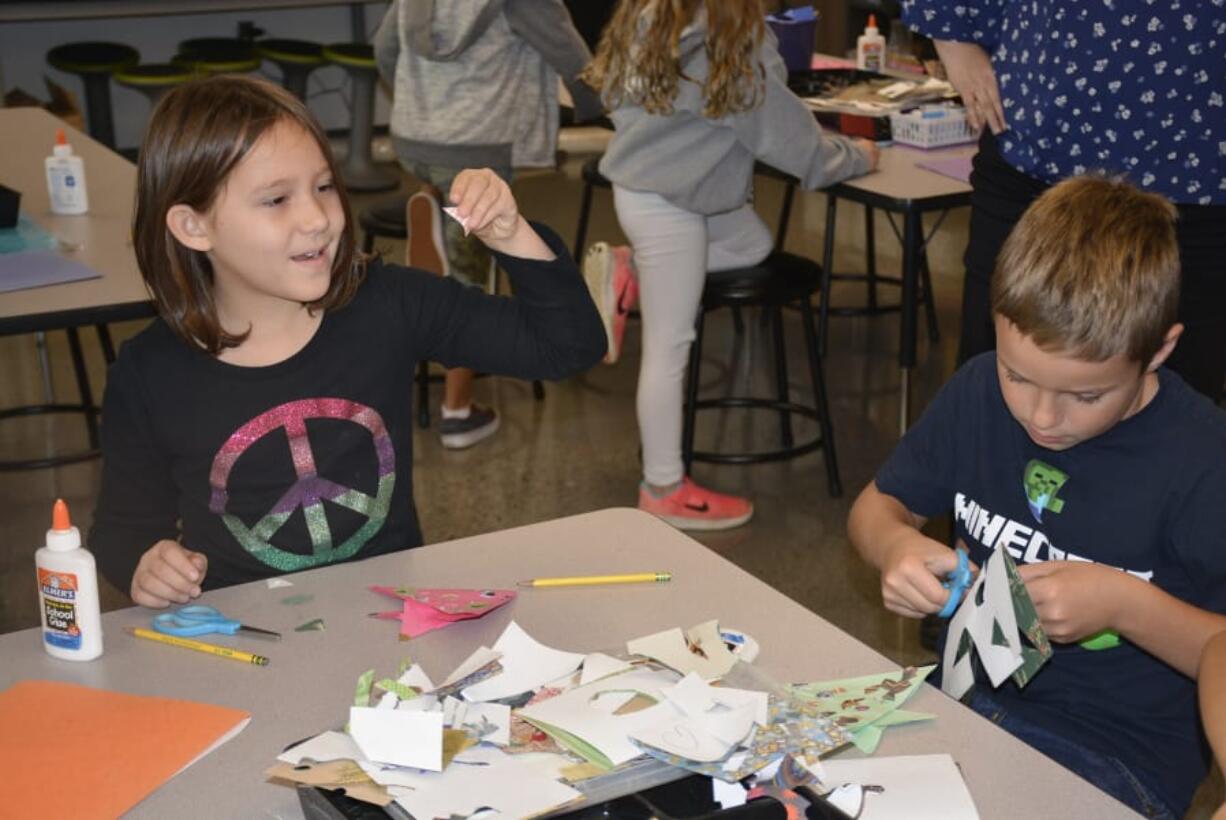 Washougal: Columbia River Gorge Elementary School second-graders, from left, Justice LaFrance and Jackson Joyce fold origami fish to be used as ornaments on Gov. Jay Inslee’s holiday tree.