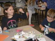 Washougal: Columbia River Gorge Elementary School second-graders, from left, Justice LaFrance and Jackson Joyce fold origami fish to be used as ornaments on Gov. Jay Inslee’s holiday tree.