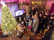 Vancouver police officers and firefighters pose for snapshots Sunday after delivering presents to the Pierro family, whose 6-year old daughter, Kierra, nearly died when she collapsed with cardiac arrest the weekend before Thanksgiving.