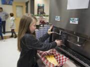 Fifth-grader Kelsey Bisconer, 11, fills up her glass with fresh chocolate milk during lunchtime Tuesday morning at Laurin Middle School. Clark County Green Schools received a $40,000 grant from the Washington Department of Ecology to install the dispensers at schools in Clark County.