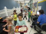 Kindergartners at Pleasant Valley Primary pick up lunch items and pay for their meals in a hallway because the school does not have a cafeteria, as seen on Tuesday morning, Oct. 4, 2016.