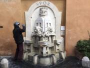 A man drinks water he collected from the 1925 Artists fountain last month in Rome’s Via Margutta.