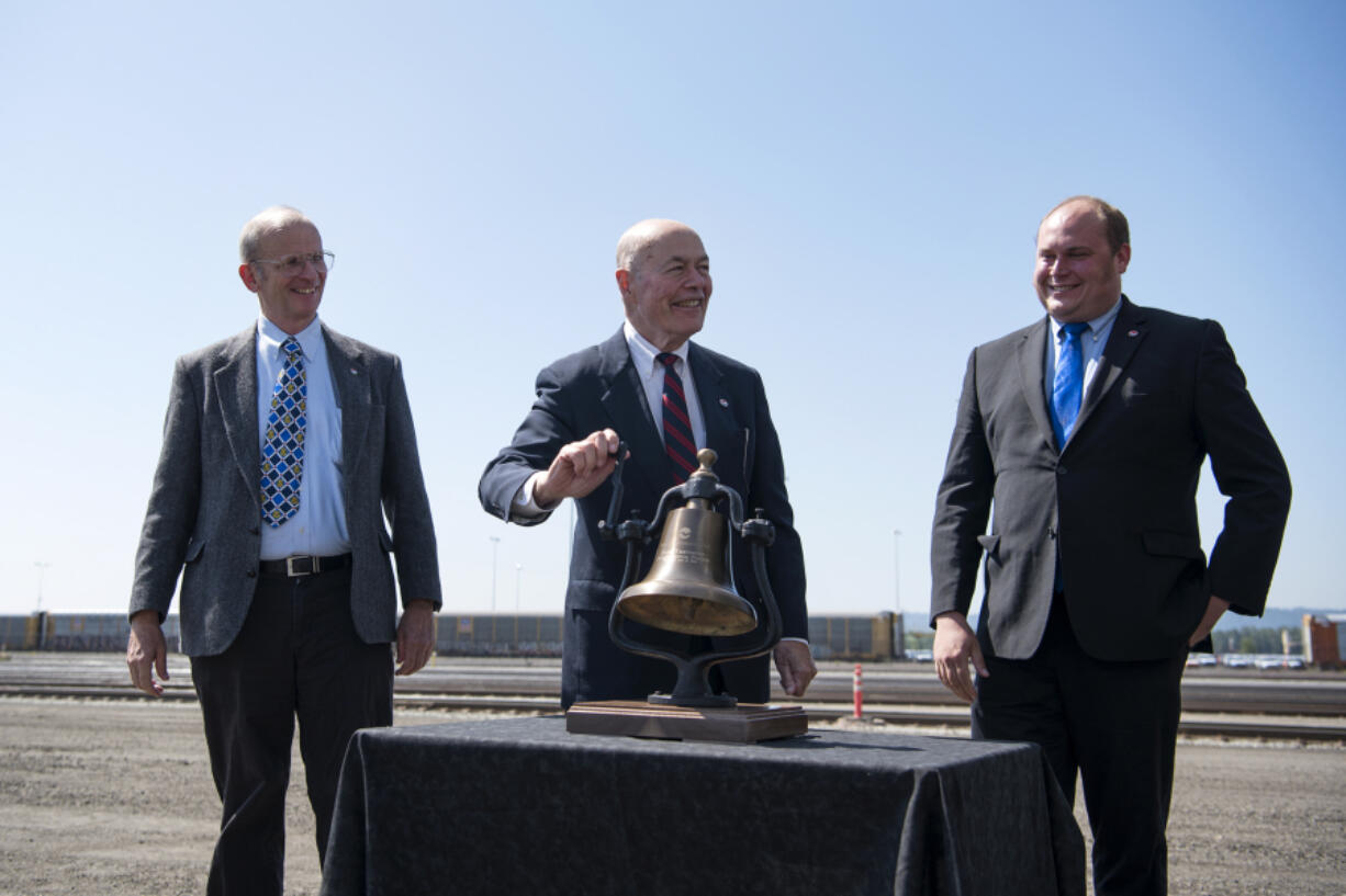 Port of Vancouver Commissioners Don Orange, from left, Jerry Oliver, and Eric LaBrant dedicate the completed West Vancouver Freight Access project with the ringing of an antique train bell replica during the grand opening ceremony on July 31.