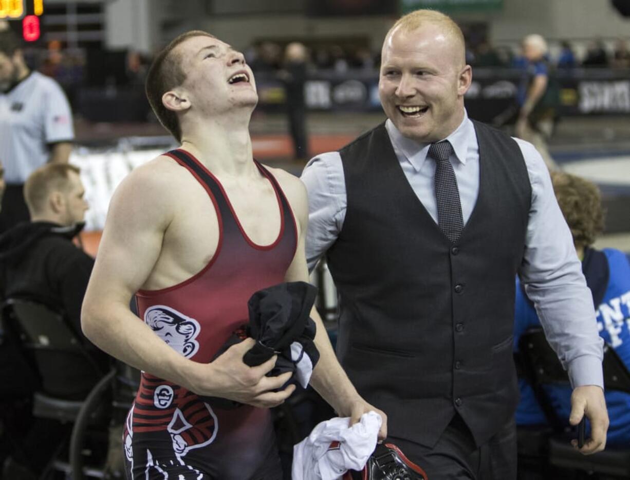 Camas’ Tanner Craig, left, and asst. coach Zane Freschette after Craig won the 132-pound state championship.