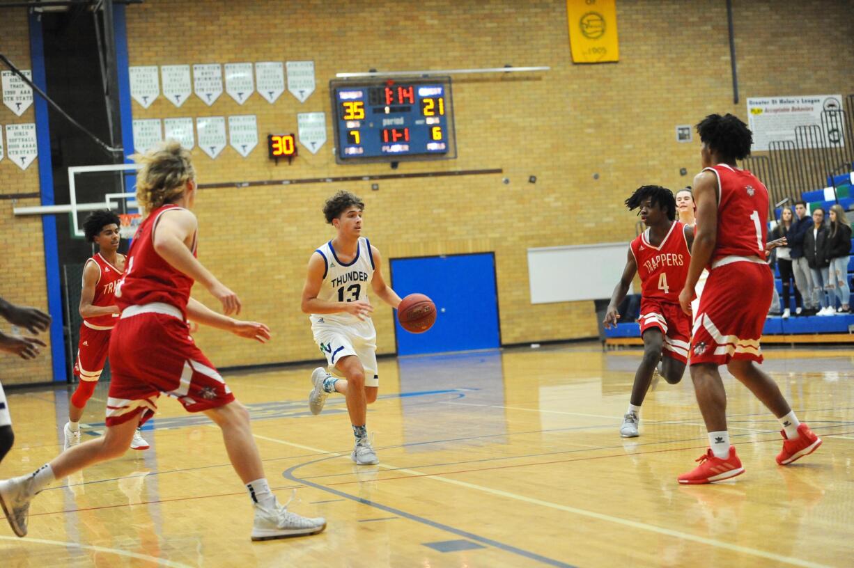 Four Fort Vancouver defenders collapse in the lane at Mountain View guard Sam Frosh drive to the hoop during the Thunder's 79-50 win on Tuesday night at Mountain View High School.