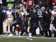 Seattle Seahawks middle linebacker Bobby Wagner, left, runs with defensive end Frank Clark (55) after intercepting a pass and running for a 98-yard touchdown against the San Francisco 49ers during the second half of an NFL football game, Sunday, Dec. 2, 2018, in Seattle.