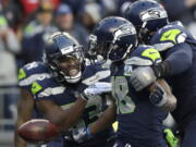 Seattle Seahawks wide receiver Jaron Brown, center, celebrates with wide receiver David Moore, left, and offensive tackle Duane Brown, right, after catching a pass for a touchdown during the second half of an NFL football game against the San Francisco 49ers, Sunday, Dec. 2, 2018, in Seattle.