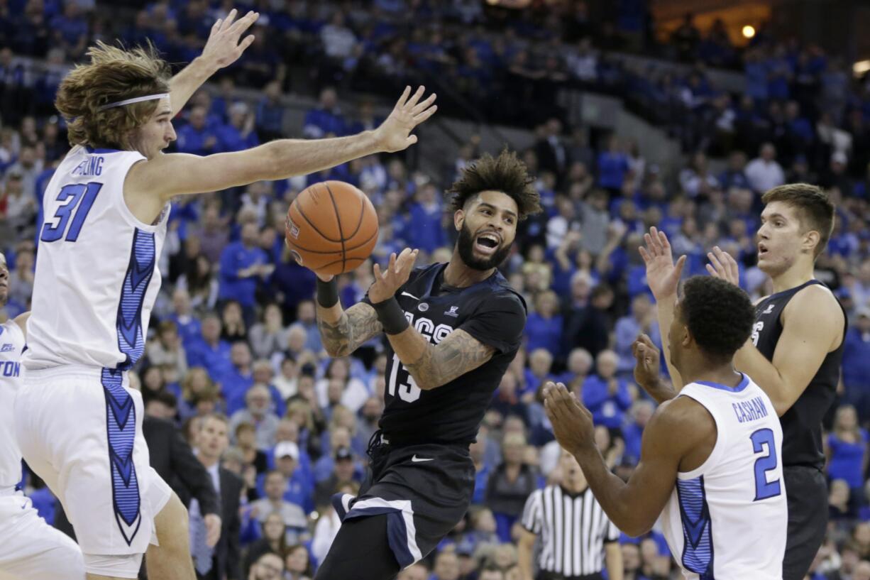 Gonzaga's Josh Perkins (13) passes the ball between Creighton's Samson Froling (31) and Connor Cashaw (2) during the first half of an NCAA college basketball game in Omaha, Neb., Saturday, Dec. 1, 2018.