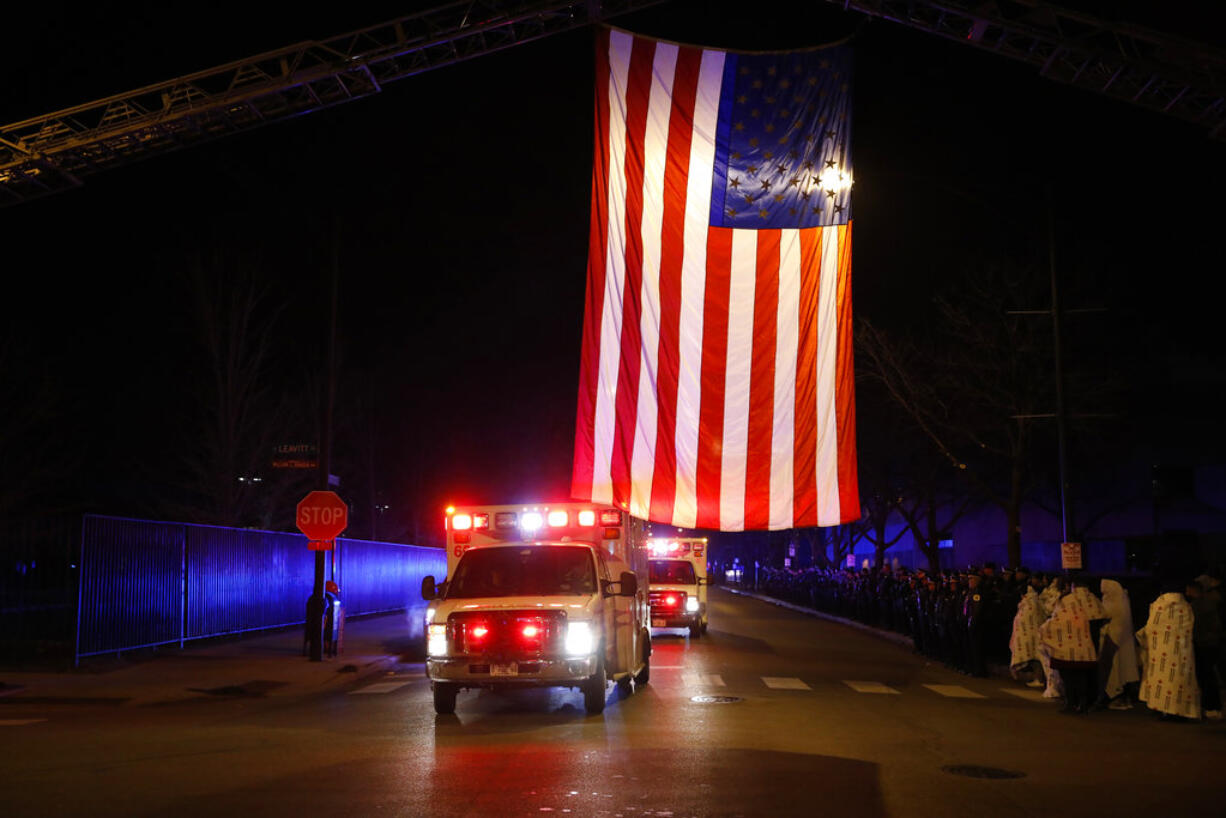 The procession with the bodies of two fallen Chicago police officers arrives to the medical examiner's office in Chicago, Tuesday morning, Dec. 18, 2018. Chicago police say two officers investigating a shots-fired call on the city’s far South Side have died after being struck by a train.. (Jose M.