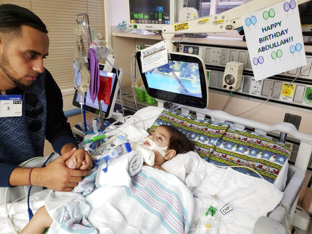 This recent but undated photo, released Monday, Dec. 17, 2018 by the Council on American-Islamic Relations in Sacramento, Calif., shows Ali Hassan with his dying 2-year-old son Abdullah in a Sacramento hospital. The boy's Yemeni mother, blocked by the Trump administration's travel ban, has won her fight for a waiver that would allow her to travel to California to see her son. Basim Elkarra of the Council on American-Islamic Relations in Sacramento said Shaima Swileh was granted a visa Tuesday, Dec. 18, 2018, and will be flying to San Francisco on Wednesday, Dec. 19, 2018.