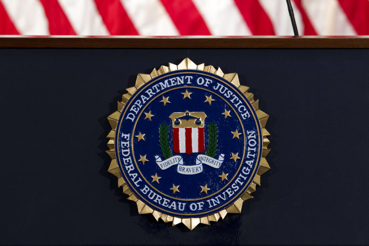 FILE - In this June 14, 2018, file photo, the FBI seal is seen before a news conference at FBI headquarters in Washington. The FBI is grappling with a seemingly endless cycle of money laundering schemes that law enforcement officials say they’re scrambling to slow through a combination of prosecution and public awareness. Beyond the run-of-the-mill plots, officials say, is a particularly concerning trend involving “money mules.” These are people who, unwittingly or not, use their own bank accounts to move money for criminals for purposes they think are legitimate or even noble.