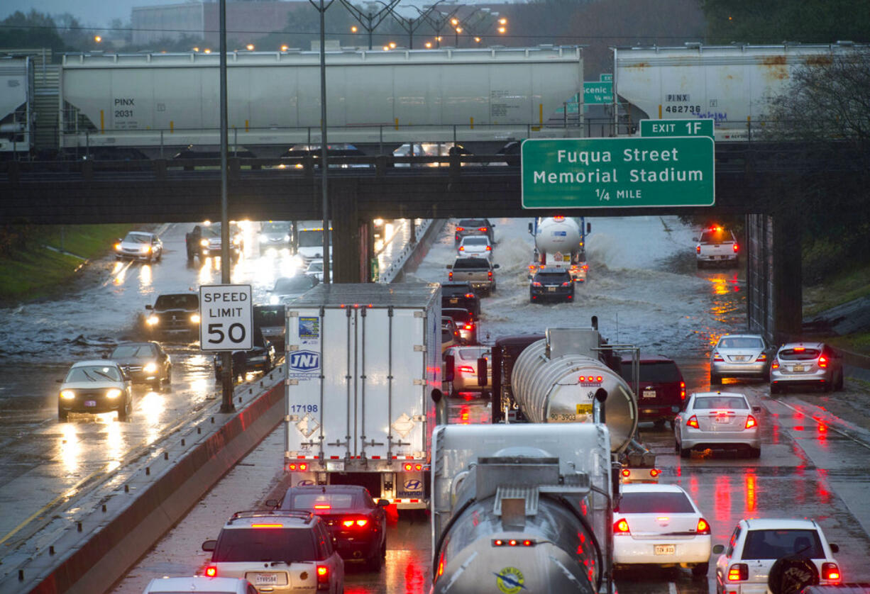 Cars stack up northbound on Interstate 110, as they encounter high water in the roadway under the railroad bridge near the governor's mansion, as even fewer vehicles opt to try to navigate the water as they progress southbound after heavy rains, Thursday, Dec. 27, 2018, in Baton Rouge, La.