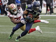 San Francisco 49ers cornerback Richard Sherman, left, tries to tackle Seattle Seahawks wide receiver Doug Baldwin during the second half of an NFL football game, Sunday, Dec. 2, 2018, in Seattle. Baldwin managed to break the tackle and gain yardage.