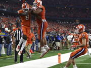 Clemson wide receiver Justyn Ross (8), defensive lineman Christian Wilkins (42) and wide receiver Hunter Renfrow (13) celebrates touchdown scored by Ross in the first half of the NCAA Cotton Bowl semi-final playoff football game against Notre Dame on Saturday, Dec. 29, 2018, in Arlington, Texas.