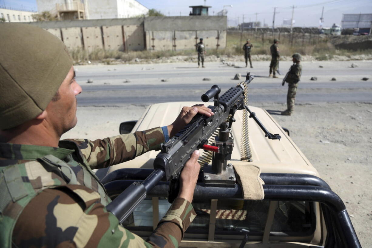 In this Wednesday, Oct. 17, 2018, photo, Afghan National Army soldiers stand guard at a checkpoint in Kabul, Afghanistan. The Taliban welcomed the news of the U.S. plan to withdraw half its troops in Afghanistan by the summer, while Afghan generals warned Friday Dec. 21, 2018, it would be a blow to the morale of the country’s beleaguered security forces, who come under daily attacks from the insurgent fighters.