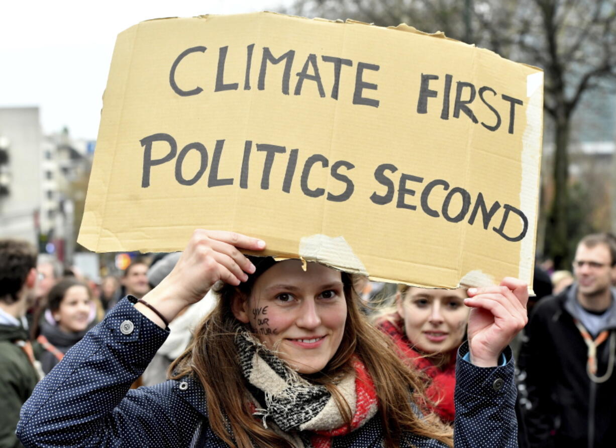 A demonstrator holds a placard which reads ‘climate first, politics second’ during a ‘Claim the Climate’ march in Brussels, Sunday, Dec. 2, 2018. The climate change conference, COP24, will take place in Poland from Dec. 2-14.