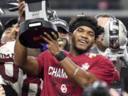 Oklahoma quarterback Kyler Murray hoists the Most Outstanding Player trophy after beating Texas 39-27 in the Big 12 Conference championship NCAA college football game on Saturday, Dec. 1, 2018, in Arlington, Texas.