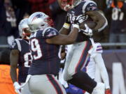 New England Patriots running back James White, right, celebrates his touchdown run with lineman Shaq Mason during the first half of an NFL football game against the Buffalo Bills, Sunday, Dec. 23, 2018, in Foxborough, Mass.