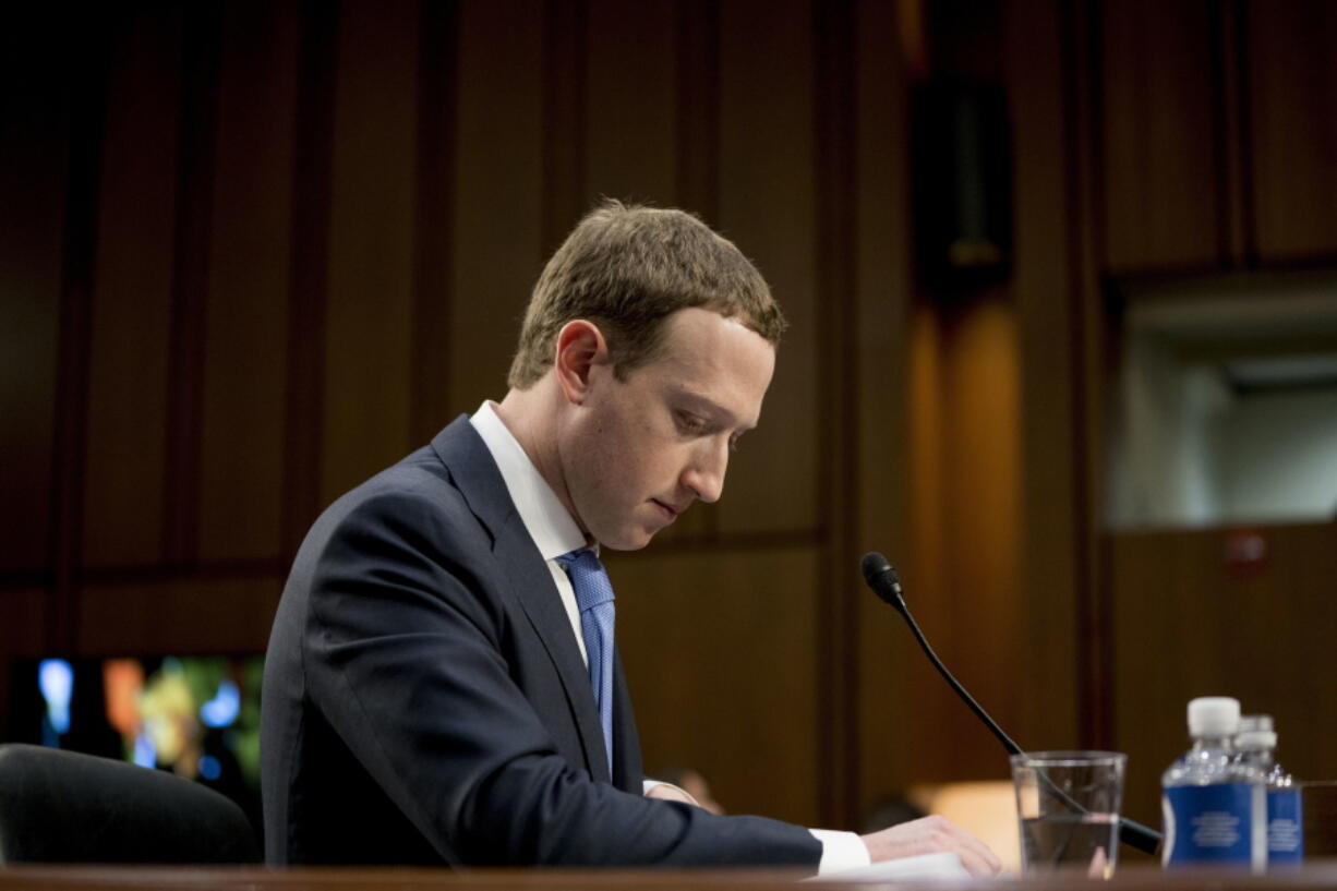 FILE- In this April 10, 2018, file photo Facebook CEO Mark Zuckerberg pauses while testifying before a joint hearing of the Commerce and Judiciary Committees on Capitol Hill in Washington about the use of Facebook data to target American voters in the 2016 election. The British Parliament has released some 250 pages worth of documents that show Facebook considered charging developers for data access. The documents show internal discussions about linking data to revenue.