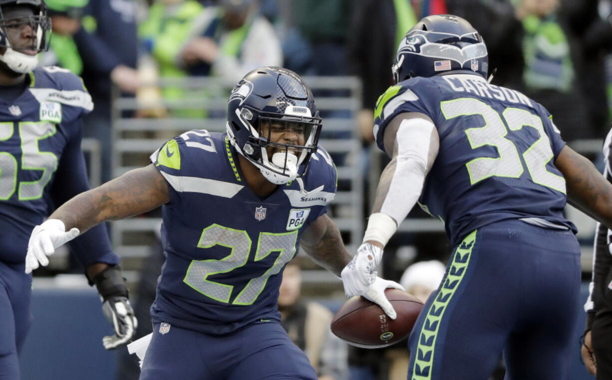 Seattle Seahawks’ Mike Davis (27) celebrates his touchdown with Chris Carson during the second half of an NFL football game against the Arizona Cardinals, Sunday, Dec. 30, 2018, in Seattle. (AP Photo/Ted S.