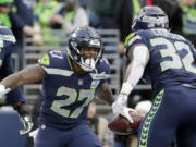 Seattle Seahawks’ Mike Davis (27) celebrates his touchdown with Chris Carson during the second half of an NFL football game against the Arizona Cardinals, Sunday, Dec. 30, 2018, in Seattle. (AP Photo/Ted S.