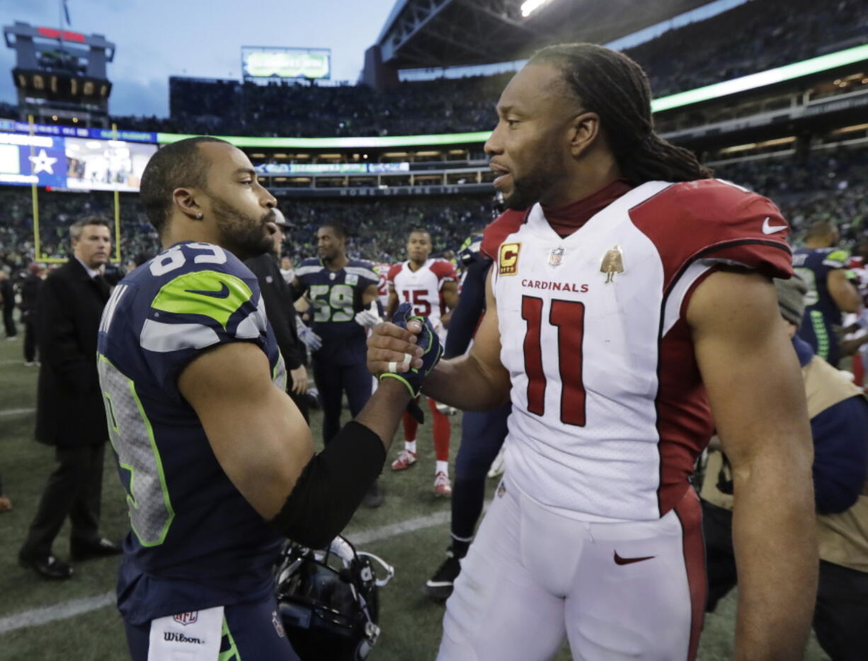 Seattle Seahawks’ Doug Baldwin, left, greets Arizona Cardinals’ Larry Fitzgerald after an NFL football game, Sunday, Dec. 30, 2018, in Seattle. (AP Photo/Ted S.