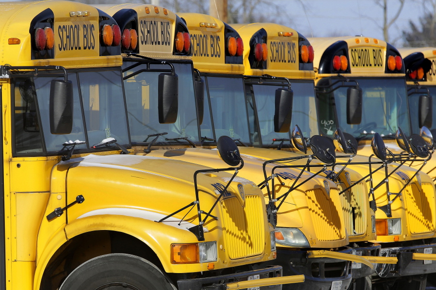 FILE - This Jan. 7, 2015 file photo shows public school buses parked in Springfield, Ill. Child abuse increases the day after school report cards are released -- but only when kids get their grades on a Friday, a Florida study released on Monday, Dec. 17, 2018 suggests.