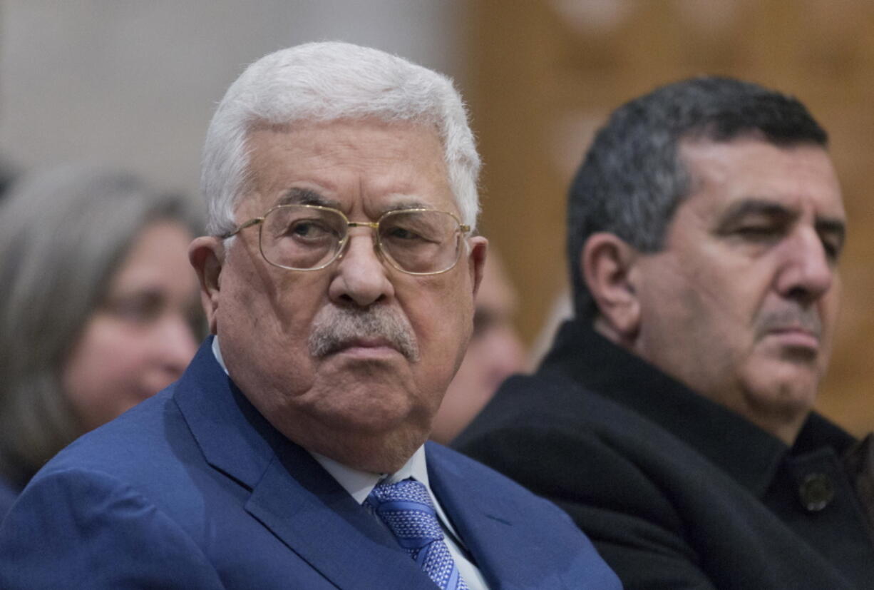 Palestinian President Mahmoud Abbas, left, attends a Christmas midnight mass at Saint Catherine’s Church, in the Church of the Nativity, traditionally recognized by Christians to be the birthplace of Jesus Christ, in the West Bank city of Bethlehem on Tuesday.