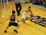 Union guard Houston Combs dribbles through back court pressure during a 79-63 win over the Papermakers on Monday night at Union High School.