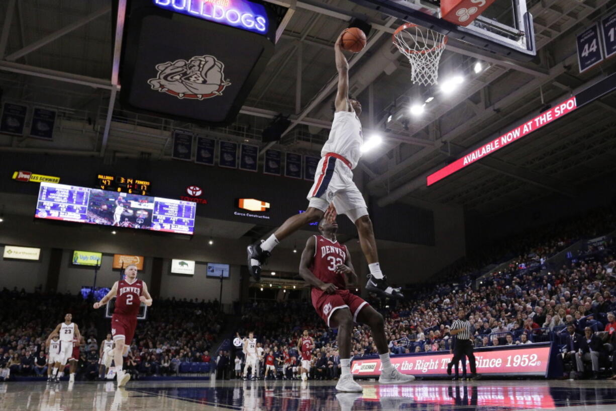 Gonzaga forward Rui Hachimura, top, dunks in front of Denver forward Abiola Akintola during the first half of an NCAA college basketball game in Spokane, Wash., Friday, Dec. 21, 2018.