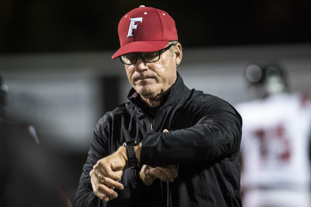 Neil Lomax, Fort Vancouver head coach, checks his watch while running warm ups before a game in the Kiggins Bowl on Friday night, Oct.